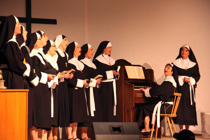 Die Moafährladies als Nonnen verkleidet, singend neben einem Harmonium auf der Bühne